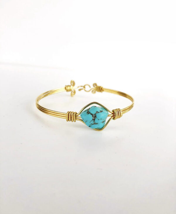 Bracelet doré avec une pierre turquoise