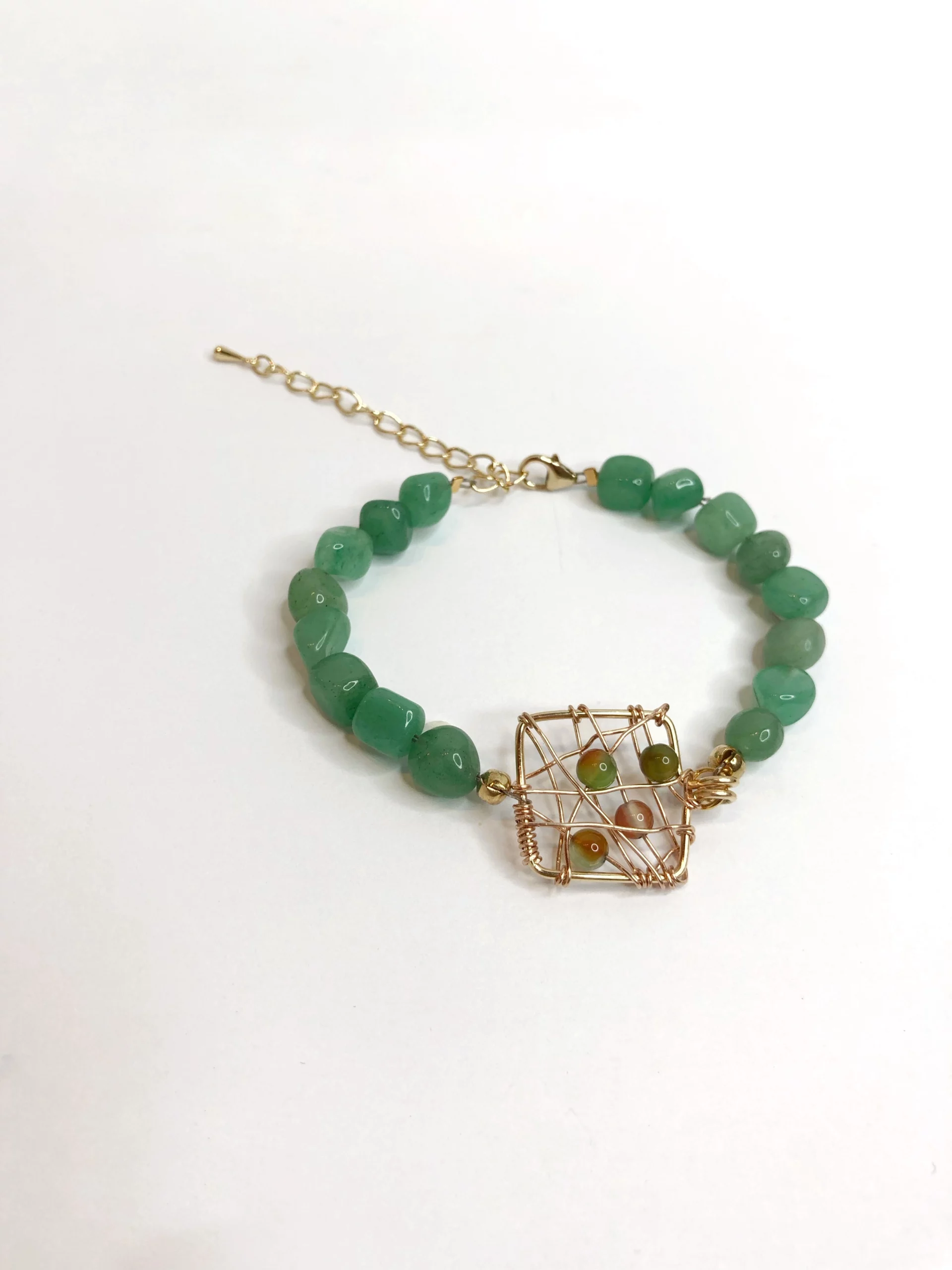 Bracelet avec pierres vertes et une médaille tissée en métal doré